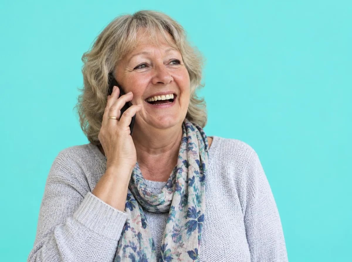 A charity worker laughing on a call.